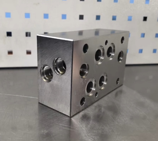 Industrial oil and gas manifold block machined from alloy steel for extreme operating conditions
